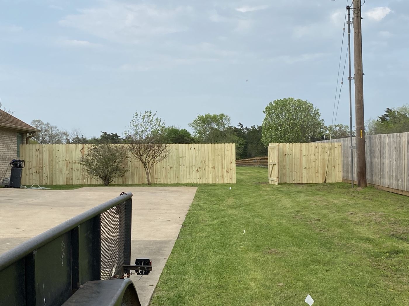 Wood privacy fence sections wrapping a backyard patio area