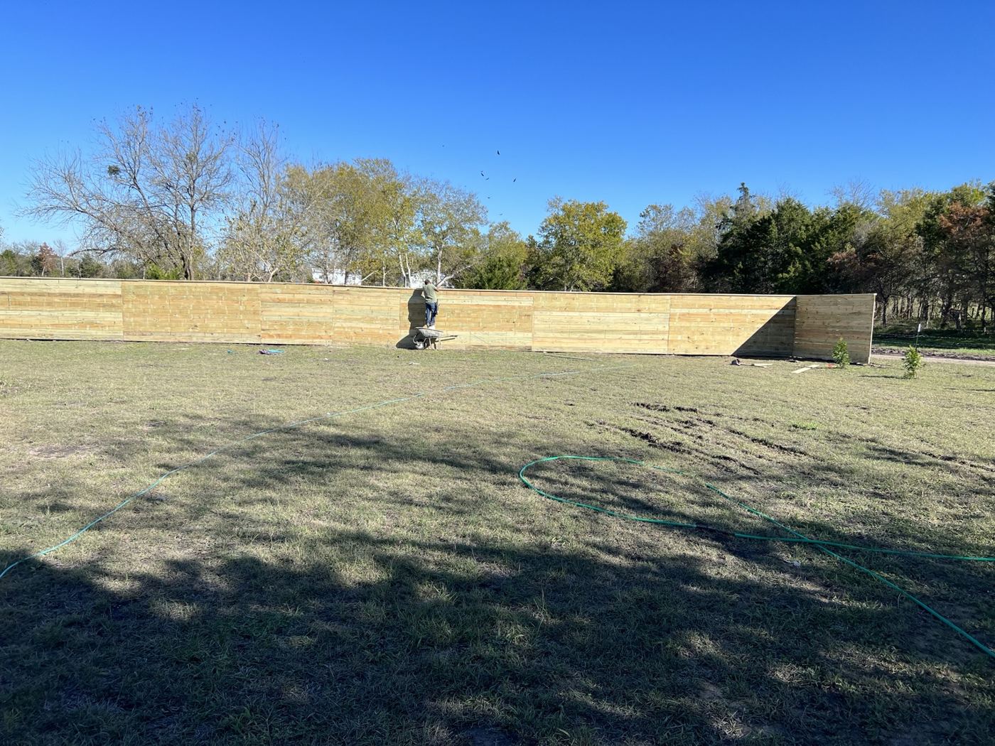 New wood privacy fence stretching across a large open property