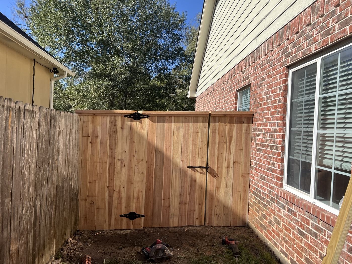 Cedar privacy fence and gate along the side of a brick home