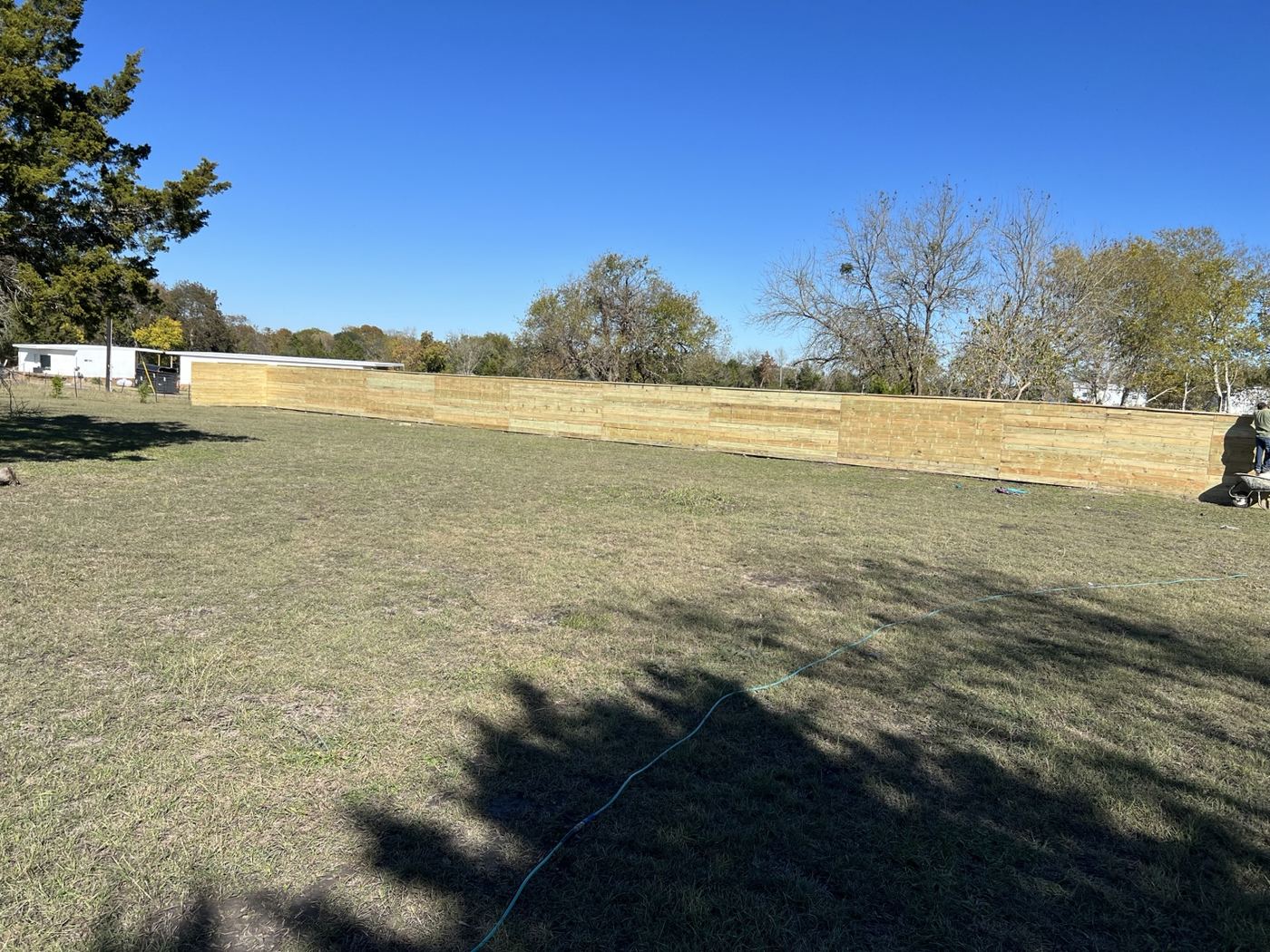 Wood privacy fence line along the back of a wide grass lot