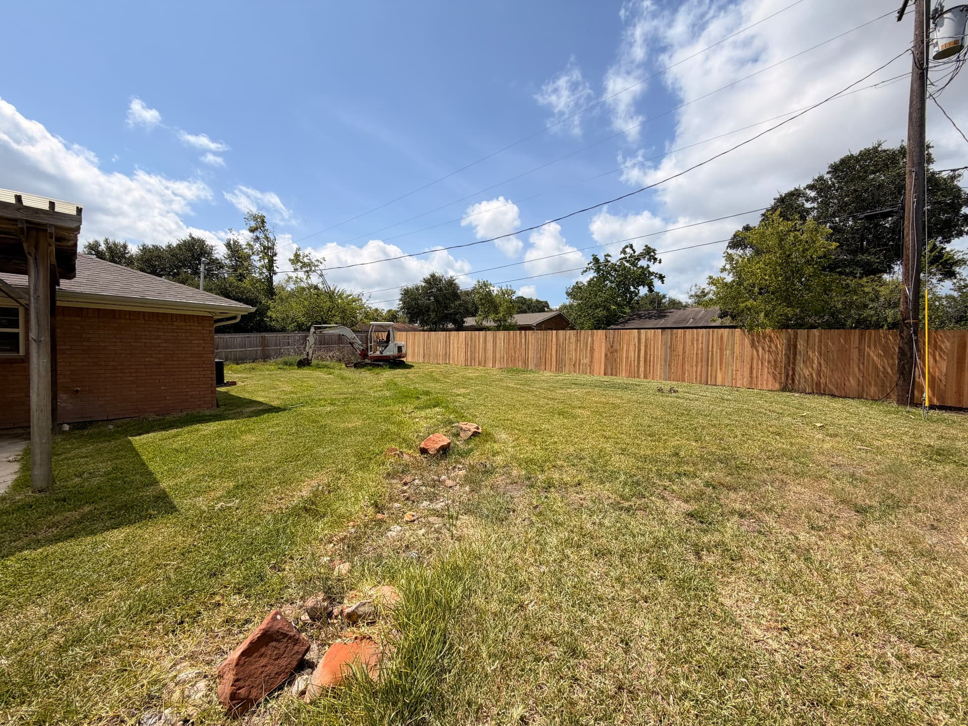 Completed cedar privacy fence running along a large Bryan TX backyard property line
